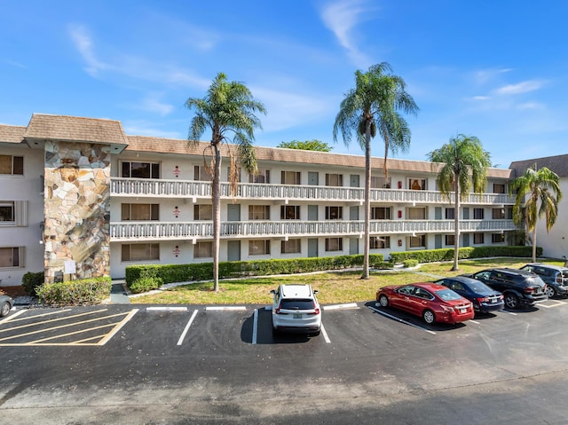 view of apartment building / complex with uncovered parking