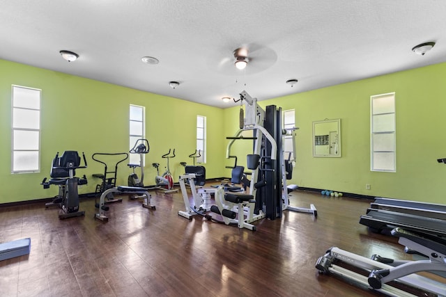 gym with baseboards, a ceiling fan, and wood finished floors