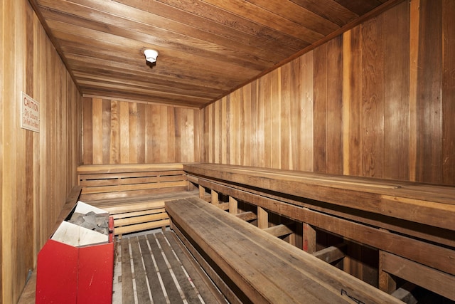 relaxing sauna featuring wooden ceiling and wood walls