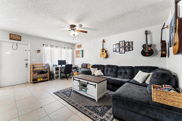 living area featuring a ceiling fan, a desk, light tile patterned floors, and a textured ceiling