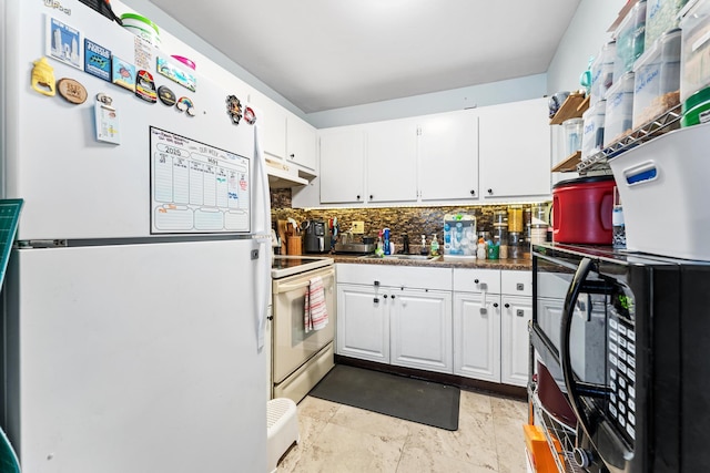 kitchen with white appliances, under cabinet range hood, decorative backsplash, and white cabinetry