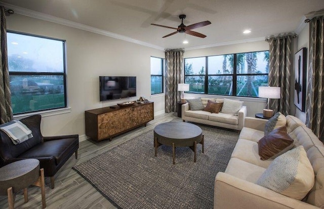 living room featuring baseboards, ornamental molding, light wood finished floors, ceiling fan, and recessed lighting