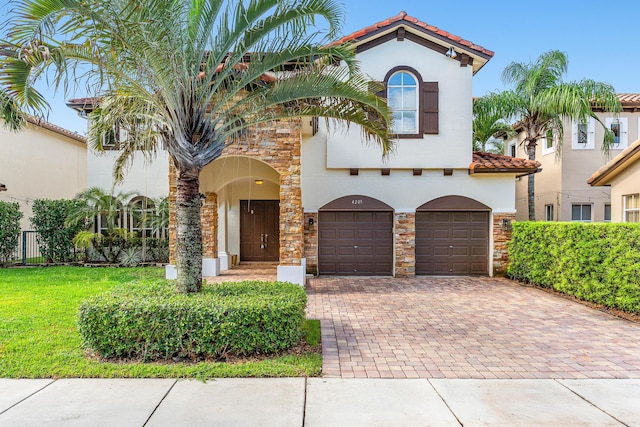 4205 Artesa Dr, Boynton Beach, FL 33436 - mediterranean / spanish house featuring stone siding, a garage, decorative driveway, stucco siding, and a tile roof