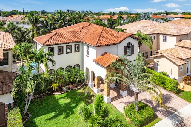 4205 Artesa Dr, Boynton Beach, FL 33436 - mediterranean / spanish home featuring a tile roof, stucco siding, a residential view, and a front lawn