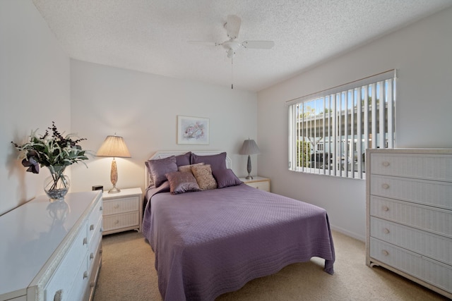 210 SE Village Dr Unit 210, Port Saint Lucie, FL 34952 - bedroom with light colored carpet, a textured ceiling, and a ceiling fan