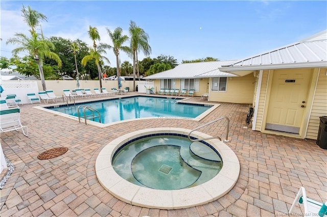 210 SE Village Dr Unit 210, Port Saint Lucie, FL 34952 - community pool featuring a hot tub, a fenced backyard, and a patio
