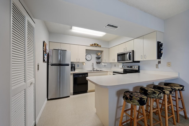 210 SE Village Dr Unit 210, Port Saint Lucie, FL 34952 - kitchen with appliances with stainless steel finishes, a peninsula, a sink, a kitchen breakfast bar, and light countertops