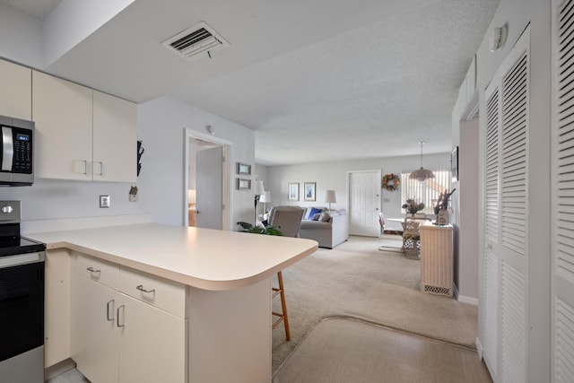 210 SE Village Dr Unit 210, Port Saint Lucie, FL 34952 - kitchen with stainless steel appliances, a peninsula, plenty of natural light, and light countertops