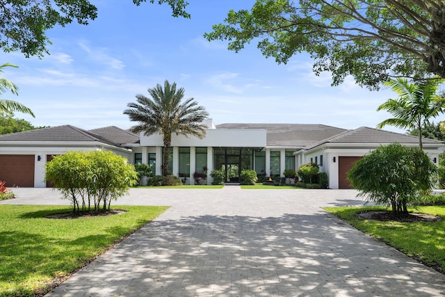 18074 Sentinel Cir, Boca Raton, FL 33496 - view of front facade with an attached garage, decorative driveway, stucco siding, and a front yard