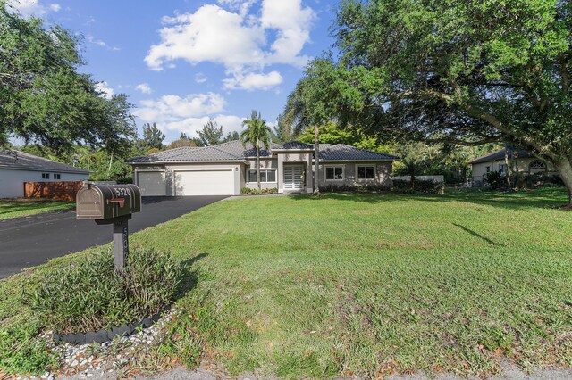5320 SW 199th Ave, Pembroke Pines, FL 33332 - view of front of house featuring asphalt driveway, an attached garage, a tiled roof, a front yard, and stucco siding