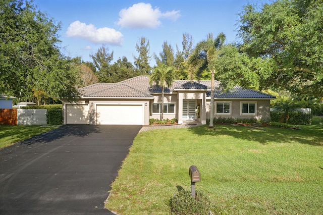 5320 SW 199th Ave, Pembroke Pines, FL 33332 - view of front of property featuring stucco siding, asphalt driveway, a front yard, an attached garage, and a tile roof