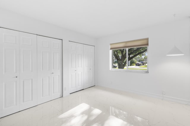 5320 SW 199th Ave, Pembroke Pines, FL 33332 - unfurnished bedroom with marble finish floors, multiple closets, and baseboards