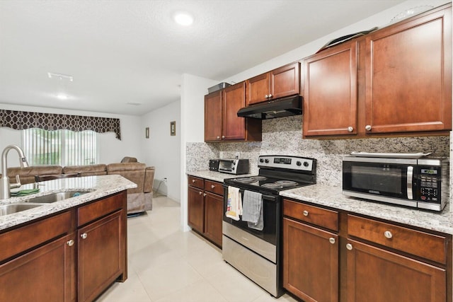 482 NW Fairfax Ave, Port Saint Lucie, FL 34983 - kitchen featuring stainless steel appliances, under cabinet range hood, a sink, backsplash, and light stone countertops