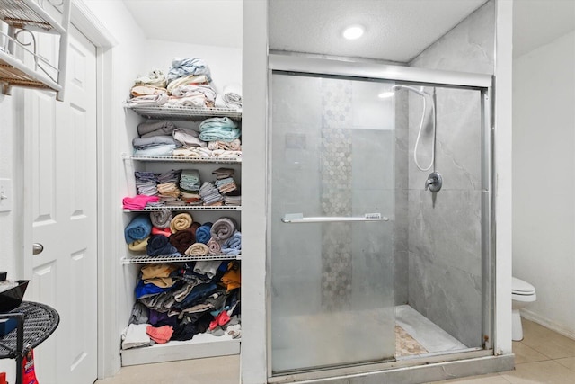 482 NW Fairfax Ave, Port Saint Lucie, FL 34983 - bathroom featuring a stall shower, toilet, tile patterned floors, recessed lighting, and a walk in closet