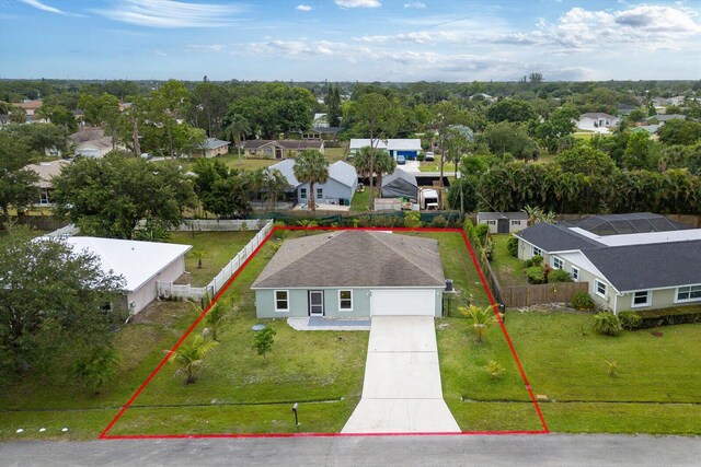 482 NW Fairfax Ave, Port Saint Lucie, FL 34983 - aerial perspective of suburban area featuring property parcel outlined and a tree filled landscape