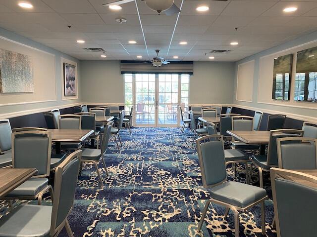 5155 Europa Dr Unit R, Boynton Beach, FL 33437 - recreation room with a decorative wall, carpet, a ceiling fan, a drop ceiling, and a wainscoted wall