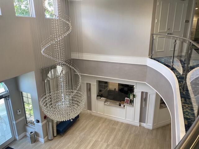 5155 Europa Dr Unit R, Boynton Beach, FL 33437 - living area with plenty of natural light, light wood finished floors, baseboards, and a chandelier