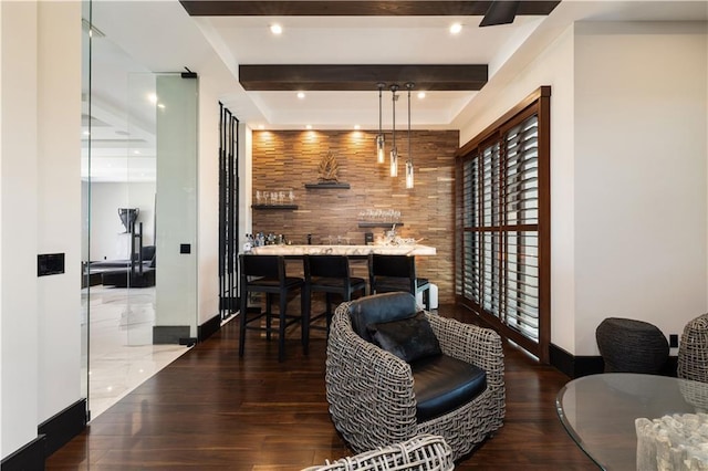 bar featuring wood finished floors, baseboards, and beamed ceiling