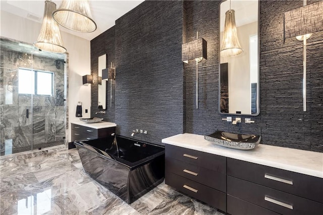 bathroom featuring a marble finish shower, marble tiled floors, a bath, and two vanities