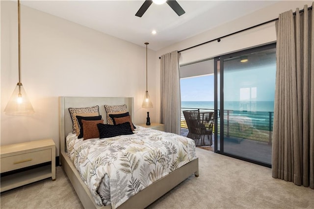 carpeted bedroom with access to exterior, a water view, and a ceiling fan