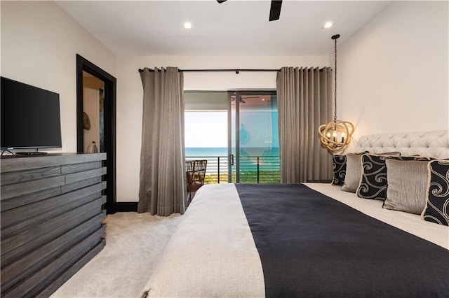 carpeted bedroom featuring access to exterior, a water view, recessed lighting, ceiling fan, and a chandelier