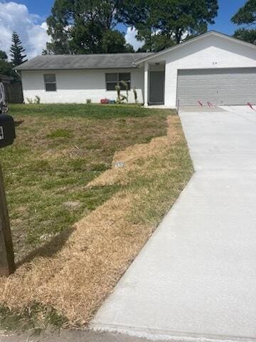 single story home featuring a garage, driveway, and a front yard