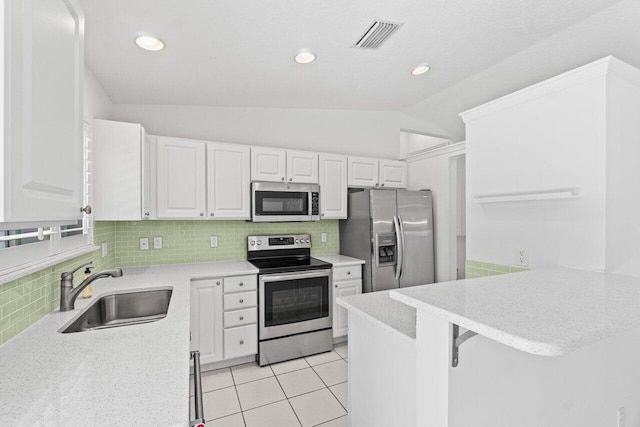 22 Pepperwood Ct, Boynton Beach, FL 33426 - kitchen with stainless steel appliances, a sink, a peninsula, backsplash, and lofted ceiling