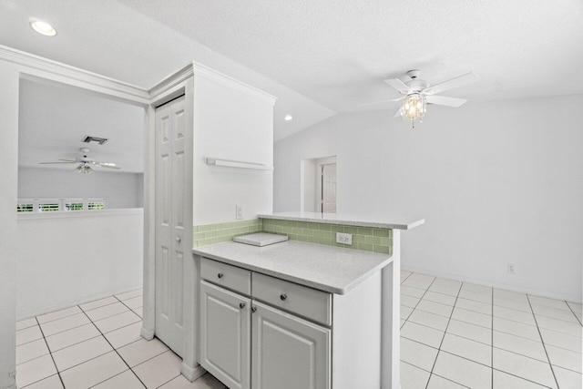 22 Pepperwood Ct, Boynton Beach, FL 33426 - kitchen with a ceiling fan, light tile patterned floors, light countertops, a peninsula, and vaulted ceiling
