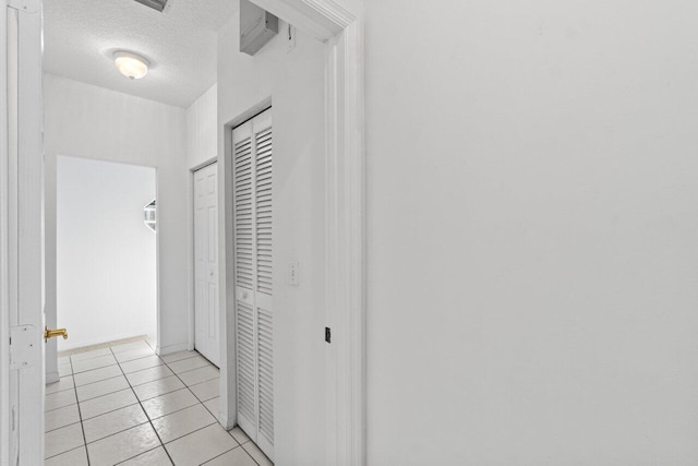 22 Pepperwood Ct, Boynton Beach, FL 33426 - corridor featuring a textured ceiling, light tile patterned floors, and baseboards