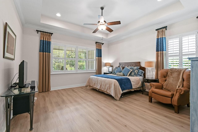 7668 SE Laque Cir, Stuart, FL 34997 - bedroom with a tray ceiling, multiple windows, light wood-style floors, baseboards, and crown molding