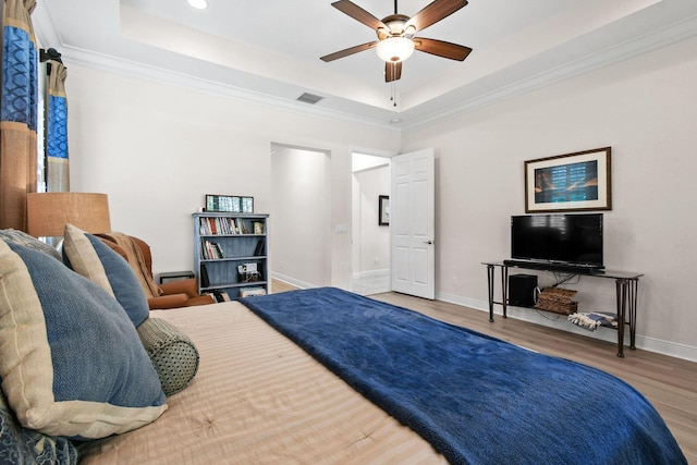 7668 SE Laque Cir, Stuart, FL 34997 - bedroom with a tray ceiling, wood finished floors, baseboards, ornamental molding, and a ceiling fan