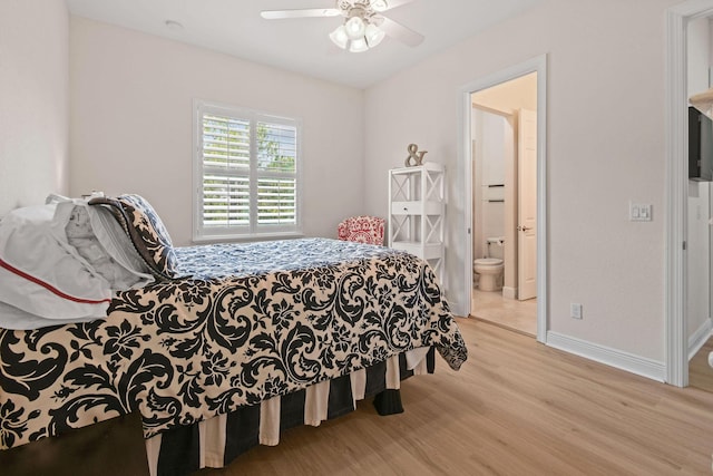 7668 SE Laque Cir, Stuart, FL 34997 - bedroom with wood finished floors, baseboards, ensuite bathroom, and ceiling fan