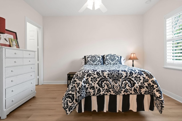 7668 SE Laque Cir, Stuart, FL 34997 - bedroom with baseboards, wood finished floors, and a ceiling fan