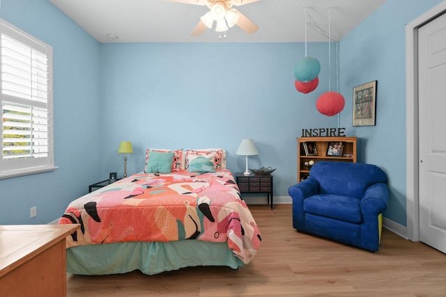 7668 SE Laque Cir, Stuart, FL 34997 - bedroom with multiple windows, wood finished floors, and baseboards