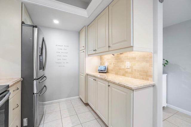 20 NE Plantation Rd Unit 203, Stuart, FL 34996 - kitchen featuring stainless steel refrigerator with ice dispenser, decorative backsplash, light tile patterned flooring, baseboards, and recessed lighting
