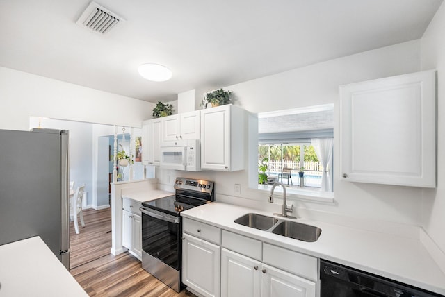 3056 SE Morningside Blvd, Port Saint Lucie, FL 34952 - kitchen featuring appliances with stainless steel finishes, a sink, white cabinetry, and light countertops