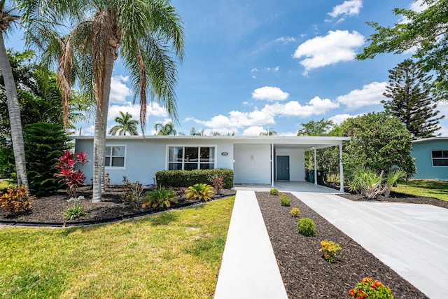 3056 SE Morningside Blvd, Port Saint Lucie, FL 34952 - ranch-style house with concrete driveway, an attached carport, a front yard, and stucco siding