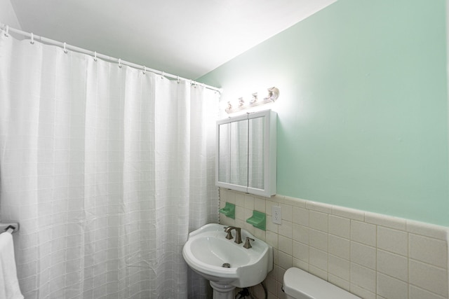 3056 SE Morningside Blvd, Port Saint Lucie, FL 34952 - bathroom with a sink, toilet, curtained shower, and tile walls