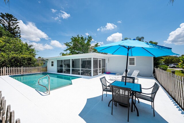 3056 SE Morningside Blvd, Port Saint Lucie, FL 34952 - view of swimming pool with a patio area, a fenced backyard, and a sunroom