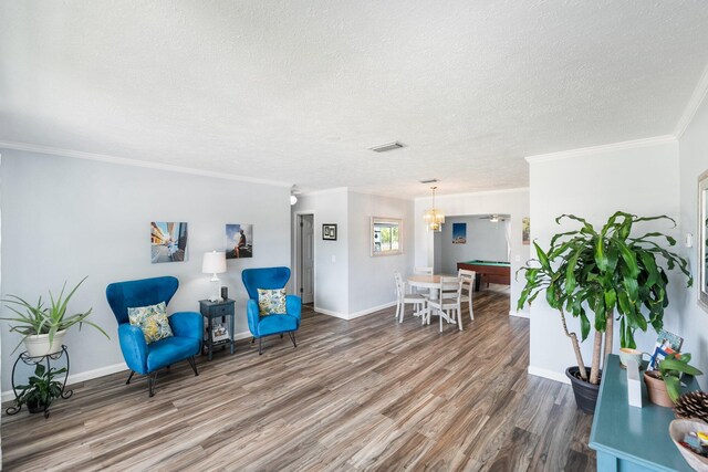 3056 SE Morningside Blvd, Port Saint Lucie, FL 34952 - sitting room featuring wood finished floors, a textured ceiling, baseboards, crown molding, and a chandelier