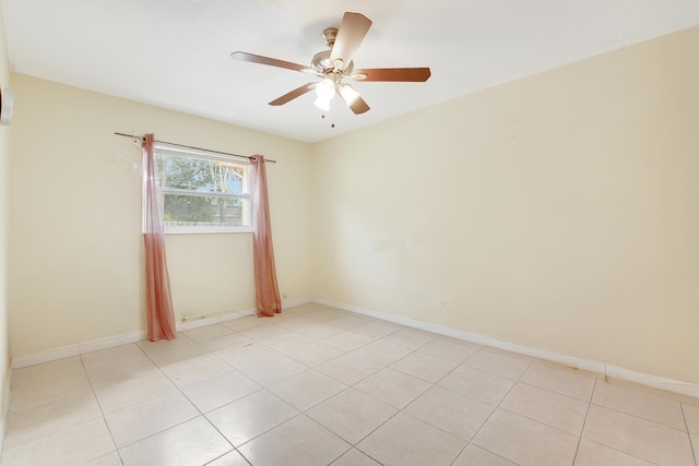 unfurnished room featuring a ceiling fan, baseboards, and light tile patterned floors