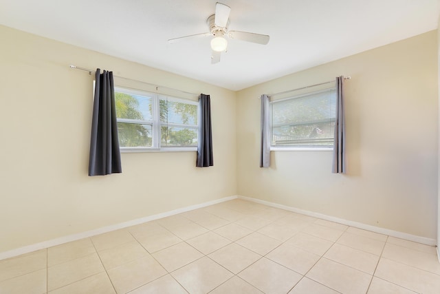unfurnished room with baseboards, light tile patterned floors, and a ceiling fan