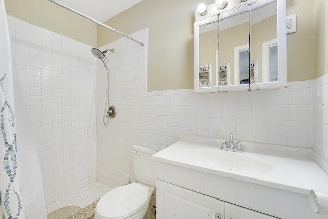 bathroom featuring tile walls, tiled shower, toilet, and vanity