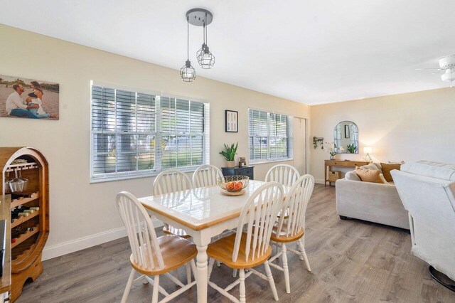 dining area with baseboards, light wood-type flooring, and a ceiling fan