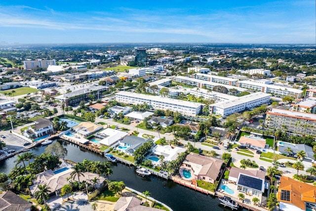 aerial view of property and surrounding area featuring nearby urban area and a large body of water