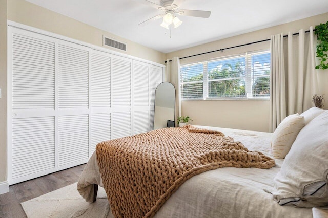 bedroom with wood finished floors, a closet, ceiling fan, and baseboards