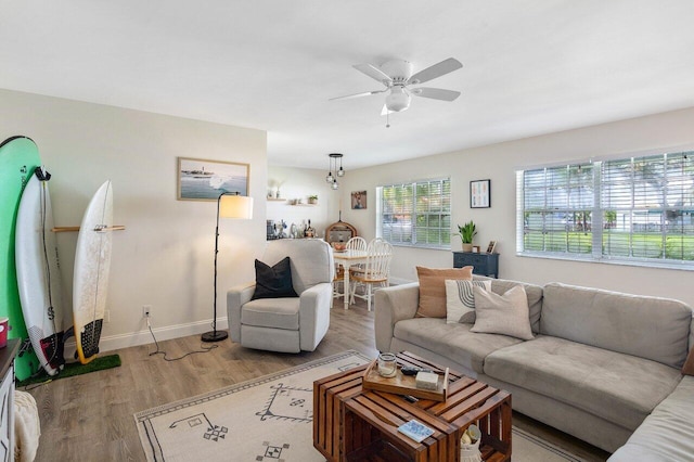 living area with ceiling fan, wood finished floors, and baseboards