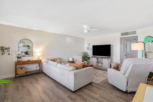 living area with a ceiling fan and wood finished floors