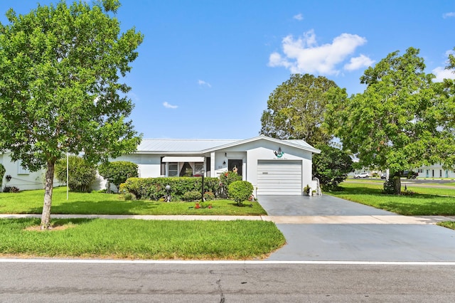 103 SW 18th St, Boynton Beach, FL 33426 - view of front of home featuring an attached garage, a front lawn, concrete driveway, stucco siding, and metal roof
