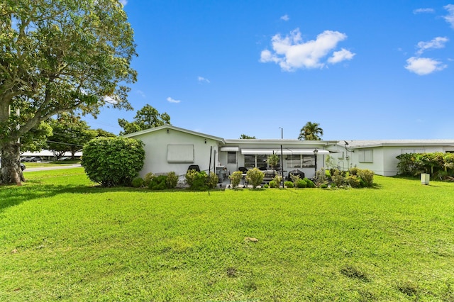 103 SW 18th St, Boynton Beach, FL 33426 - rear view of house featuring stucco siding and a lawn